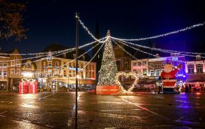 A festive night scene at Sittard's Christmas market with lights and decorations.
